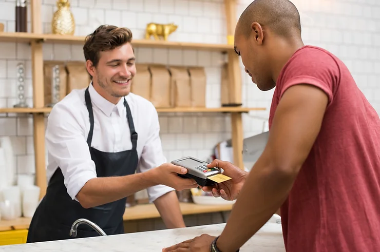 Customer making an in-store payment using a card reader, illustrating face-to-face transactions and modern retail technology.